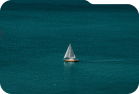 A yacht with white sails is sailing in the middle of the ocean